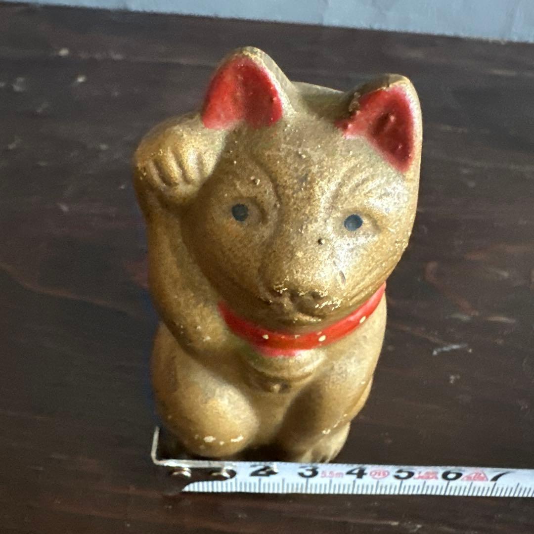 シュールなお顔の陶器製　金色の招き猫貯金箱